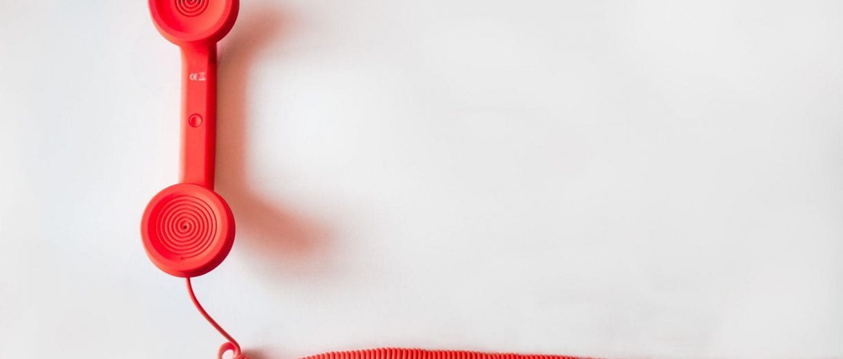 Student Services - A red cord phone on a white backdrop.