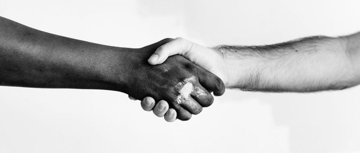 Student Services - Two people shaking hands in front of a white background.