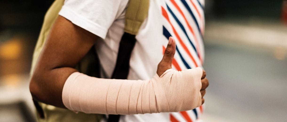 Student Services - Person with bandaged arm giving thumbs up.