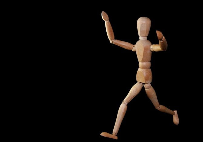 Student Services - Wooden miniature mannequin posed running.